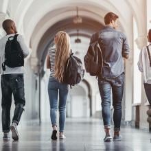 Four students walking down a hallway